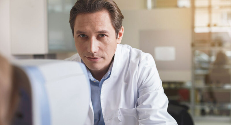 Young male doctor sitting in his bureau.