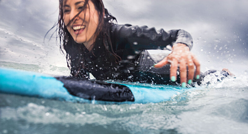 Female surfer on her board in the ocean.