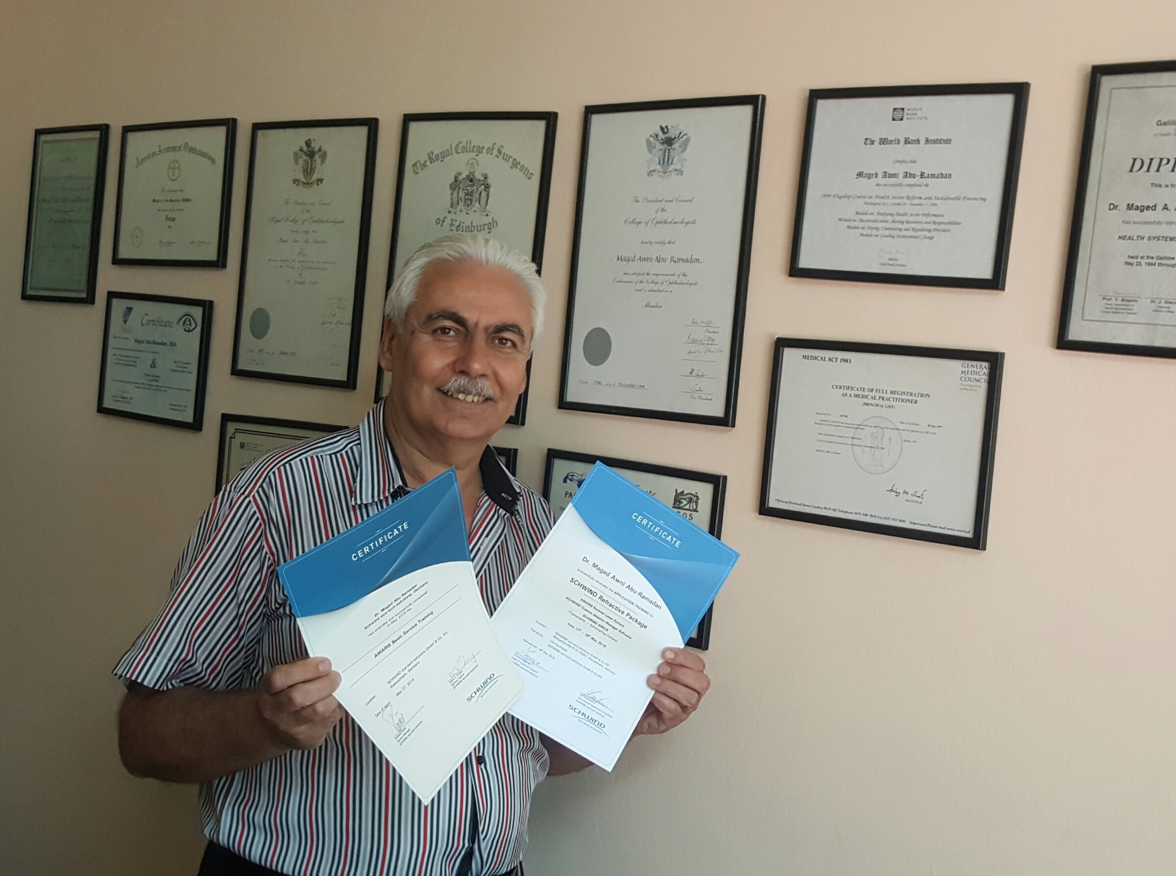 Tanned man holding two SCHWIND certificates