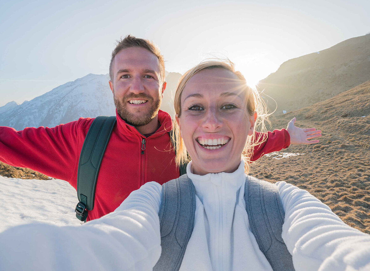 Happy couple in the mountains takes a selfie