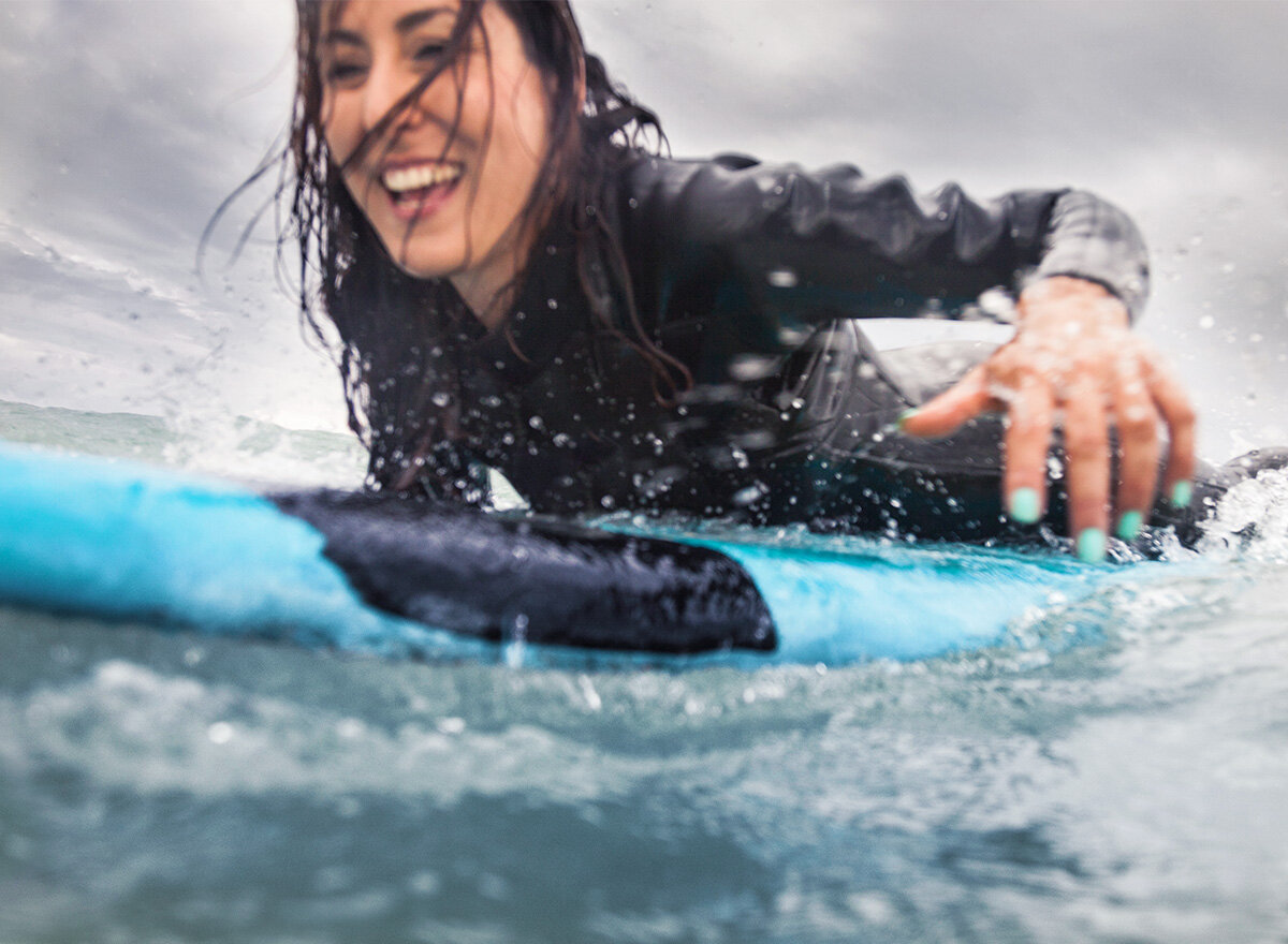 Female surfer on her board in the ocean.